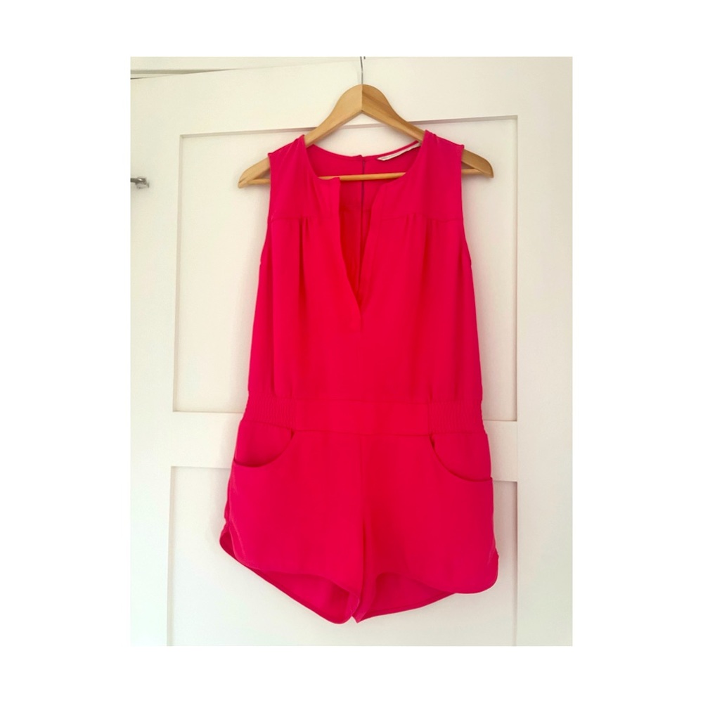 Short romper with pockets. Hot pink . Elastic waist . Button detail in back.